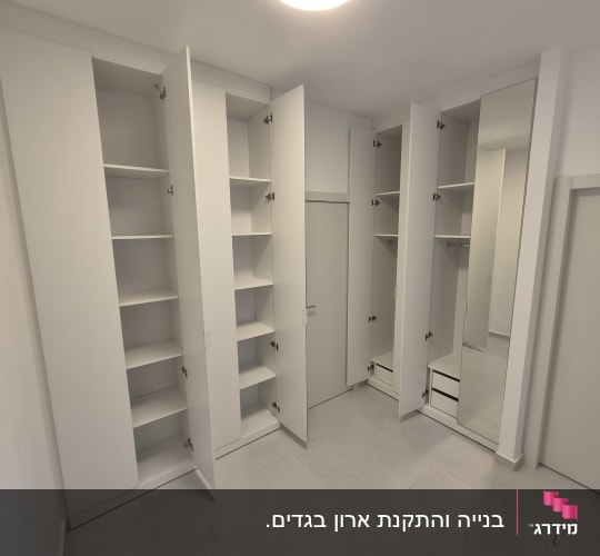 ארונות לבנים עם דלתות פתוחות ומדפים פנימיים
